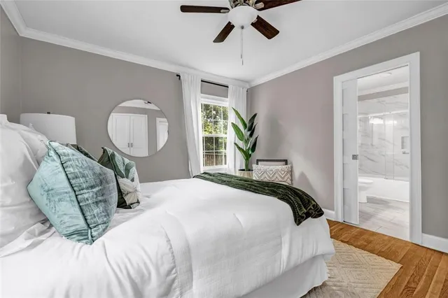 a bedroom with a large bed and wooden floor