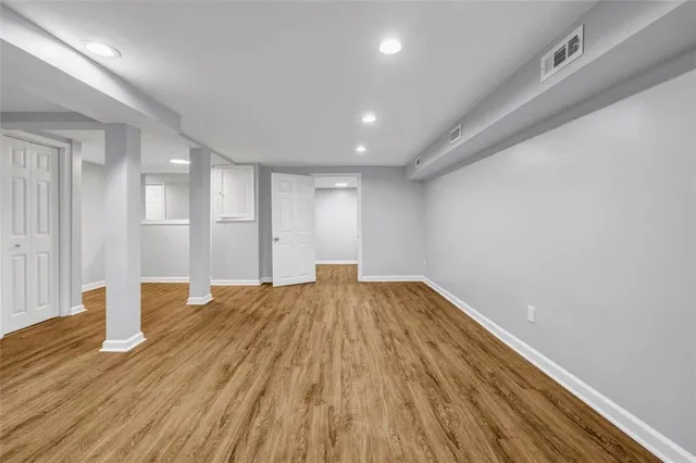 a view of empty room with wooden floor