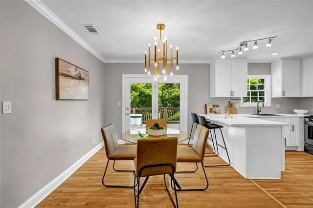 a dining room with furniture a chandelier and wooden floor