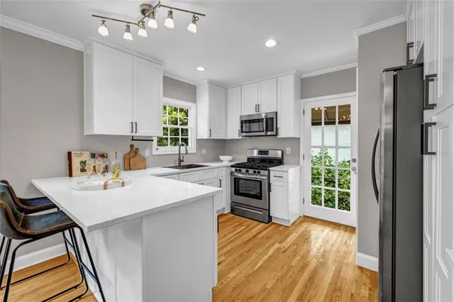 a kitchen with stainless steel appliances kitchen island granite countertop a sink stove and refrigerator