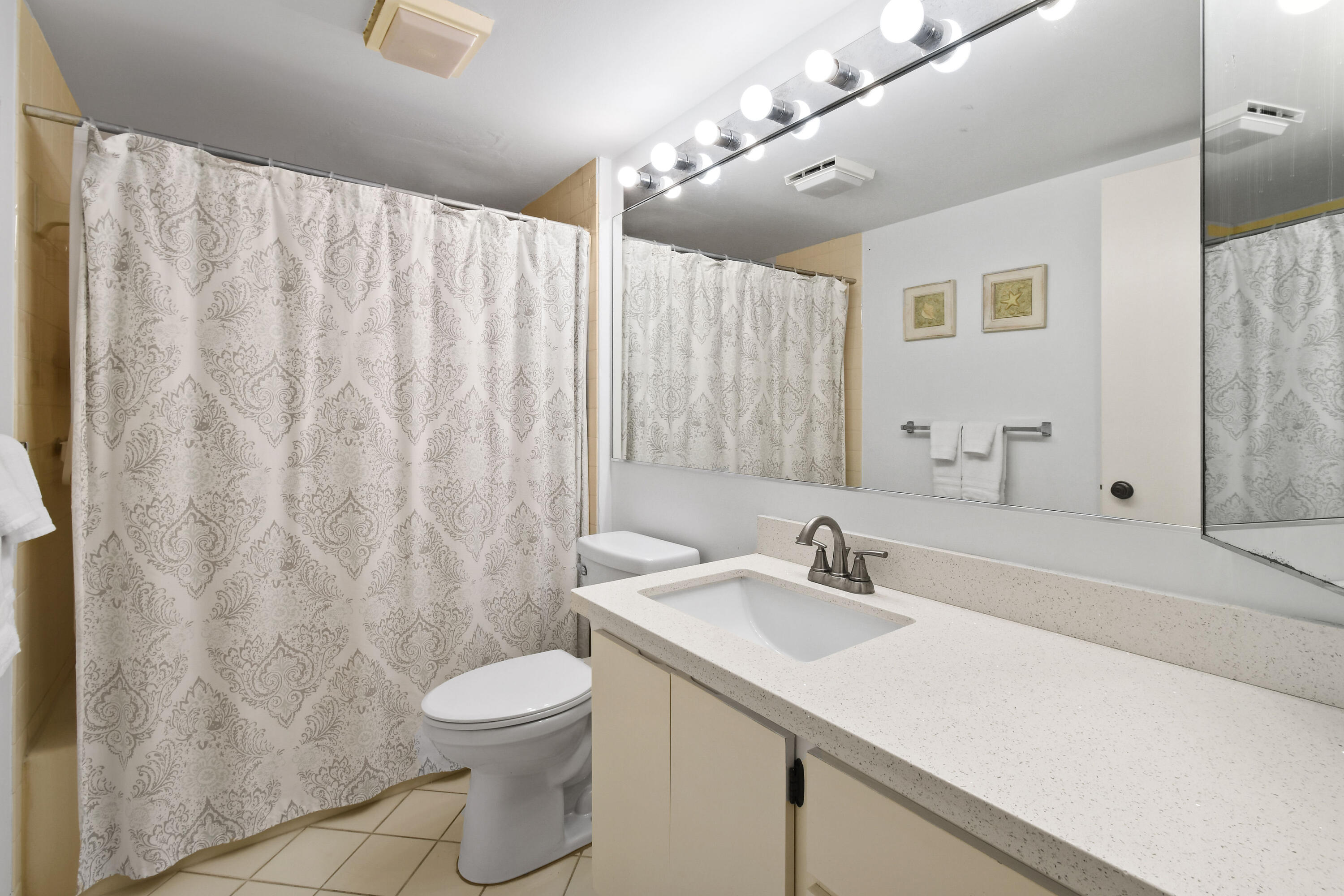 Undisclosed Address Jupiter, FL 33477 - Photo 14 of 23 a bathroom with a sink toilet a mirror and shower curtain