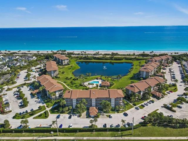 an aerial view of residential houses with outdoor space and ocean view