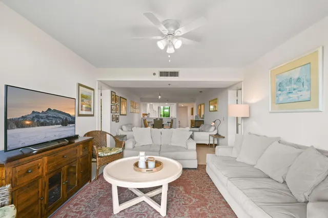 a living room with furniture a flat screen tv and kitchen view