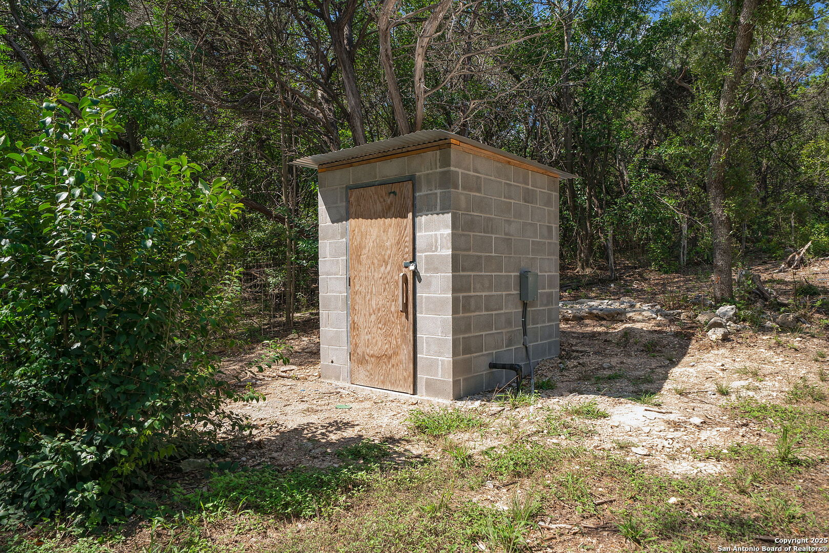10096 Whip O Will Way Helotes, TX 78023 - Photo 23 of 39 a backyard of a house with large trees and wooden fence