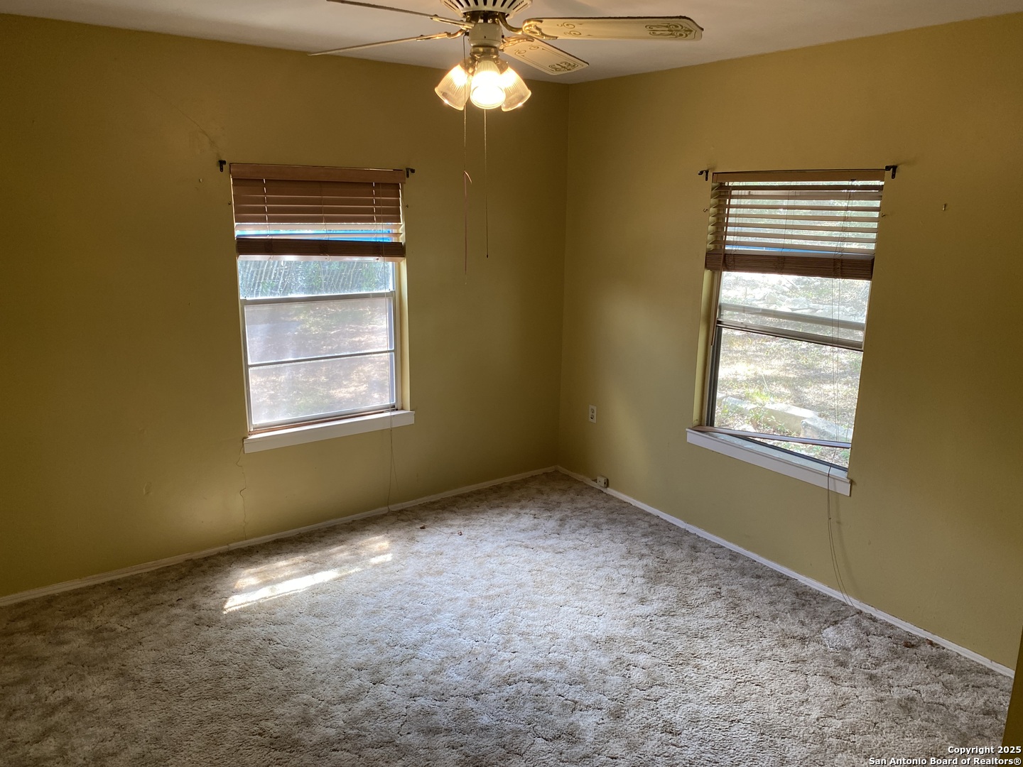 10096 Whip O Will Way Helotes, TX 78023 - Photo 35 of 39 a view of an empty room with window and chandelier fan