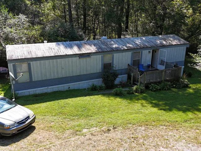 a view of a house with backyard and sitting area