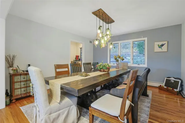a view of a dining room with furniture a chandelier and wooden floor