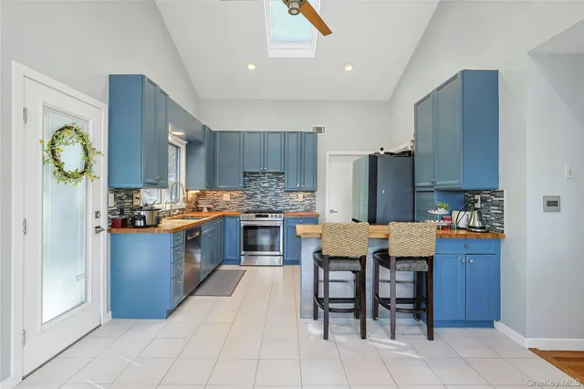 a kitchen with granite countertop a table chairs stove and refrigerator