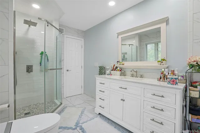 a bathroom with a sink a toilet and shower