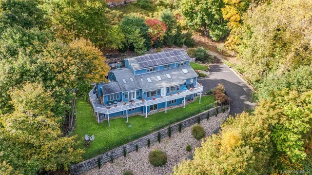 a view of a house with a big yard and large trees