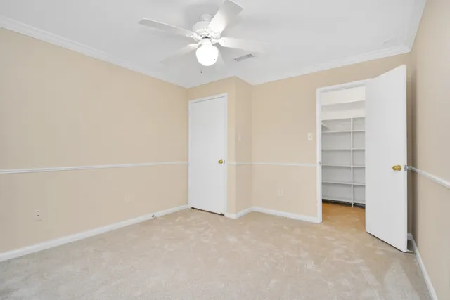 an empty room with a ceiling fan and a window