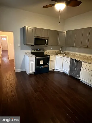 a kitchen with stainless steel appliances kitchen island granite countertop a stove a sink and a microwave