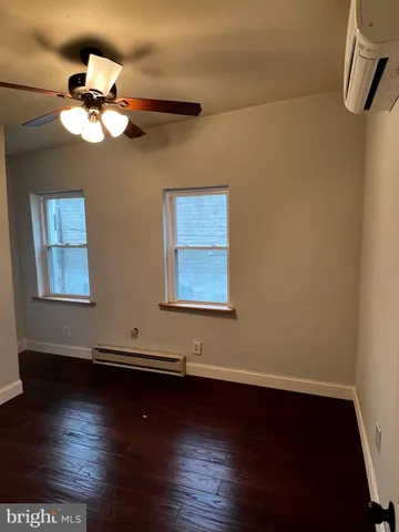 a view of wooden floor and a chandelier fan in a room