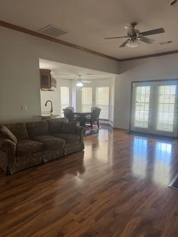 a living room with furniture and a wooden floor