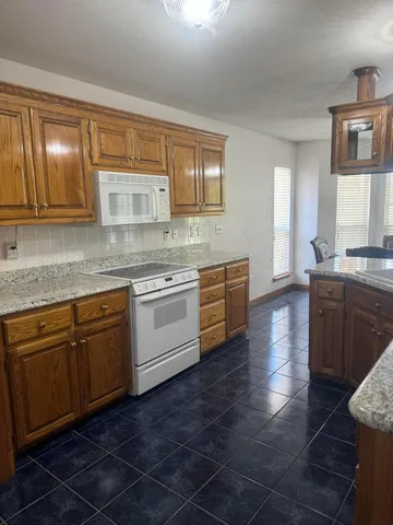 a kitchen with stainless steel appliances granite countertop a sink stove and cabinets