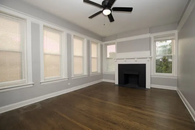 wooden floor fireplace and windows in an empty room