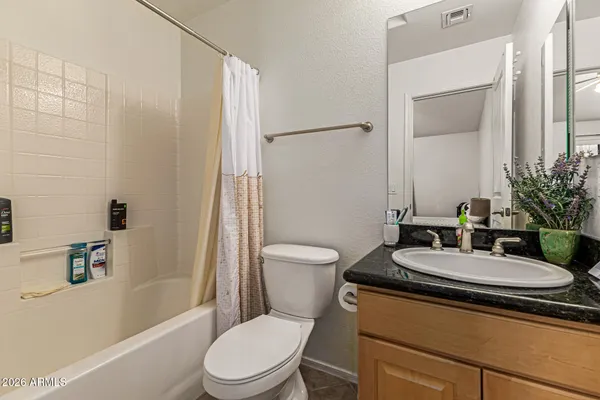 a bathroom with a sink a toilet a mirror and shower