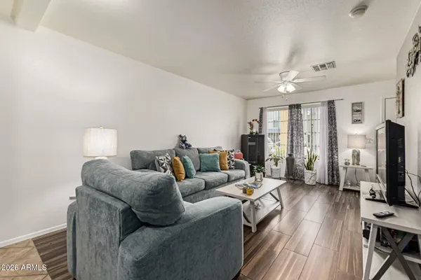 a living room with furniture a flat screen tv and a floor to ceiling window