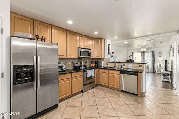 a kitchen with stainless steel appliances granite countertop a refrigerator and a stove top oven