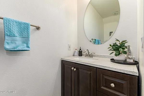 a bathroom with a granite countertop sink a mirror and vanity