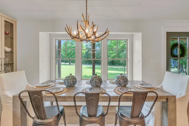 a view of a dining room with furniture large windows and wooden floor