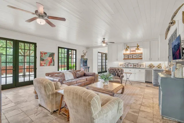 a living room with fireplace furniture and a large window