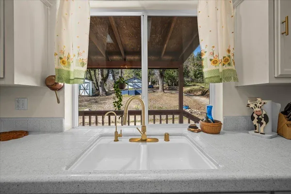 a kitchen with stainless steel appliances granite countertop a refrigerator a sink dishwasher a stove and white cabinets with wooden floor