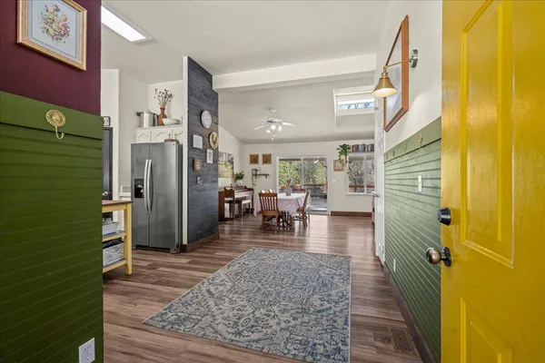 a kitchen with stainless steel appliances granite countertop a stove a sink dishwasher and white cabinets with wooden floor