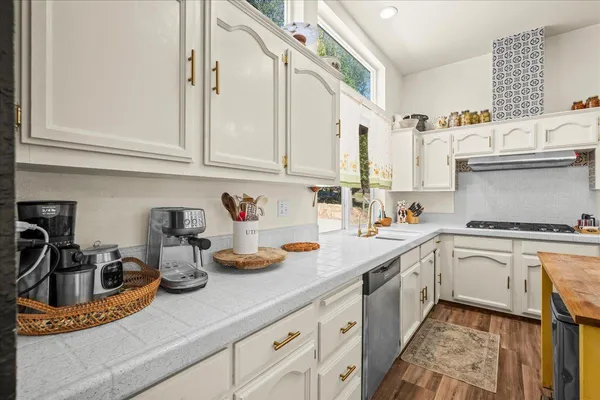 a kitchen with cabinets appliances a sink and a counter top space