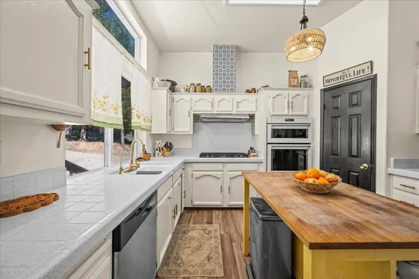 a kitchen with stainless steel appliances granite countertop a stove and white cabinets