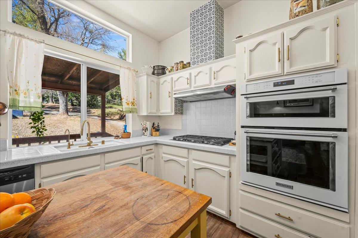 5351 Cosumnes Mine Road Somerset, CA 95684 - Photo 10 of 66 a kitchen with stainless steel appliances granite countertop a stove and white cabinets