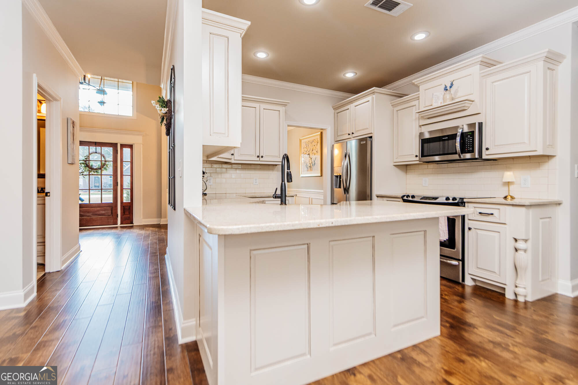 112 Bainbridge Lane Perry, GA 31069 - Photo 8 of 34 a kitchen with stainless steel appliances a microwave a stove a sink dishwasher and a refrigerator with wooden floor