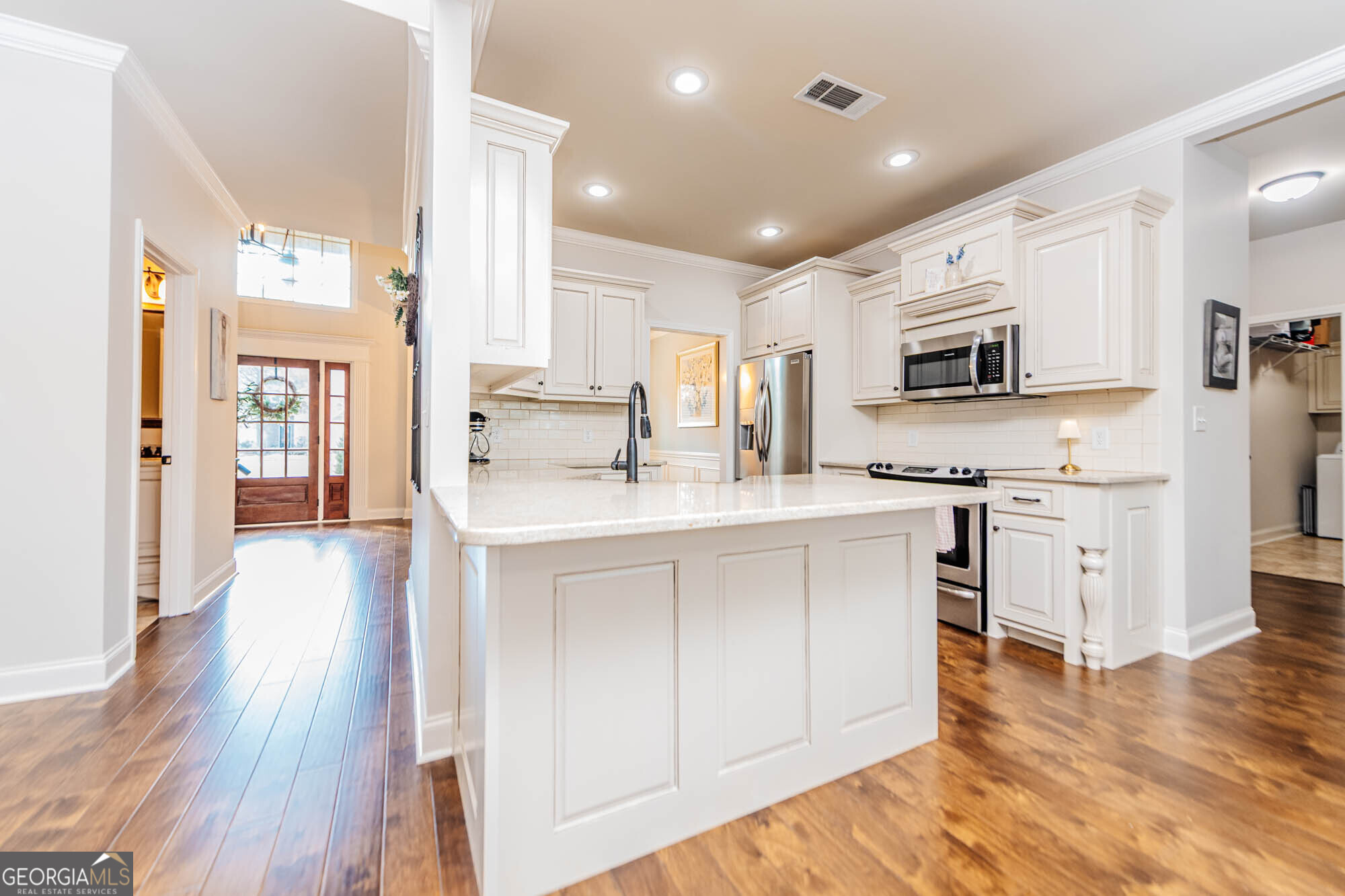 112 Bainbridge Lane Perry, GA 31069 - Photo 9 of 34 a kitchen with stainless steel appliances white cabinets a sink a stove a refrigerator and a microwave