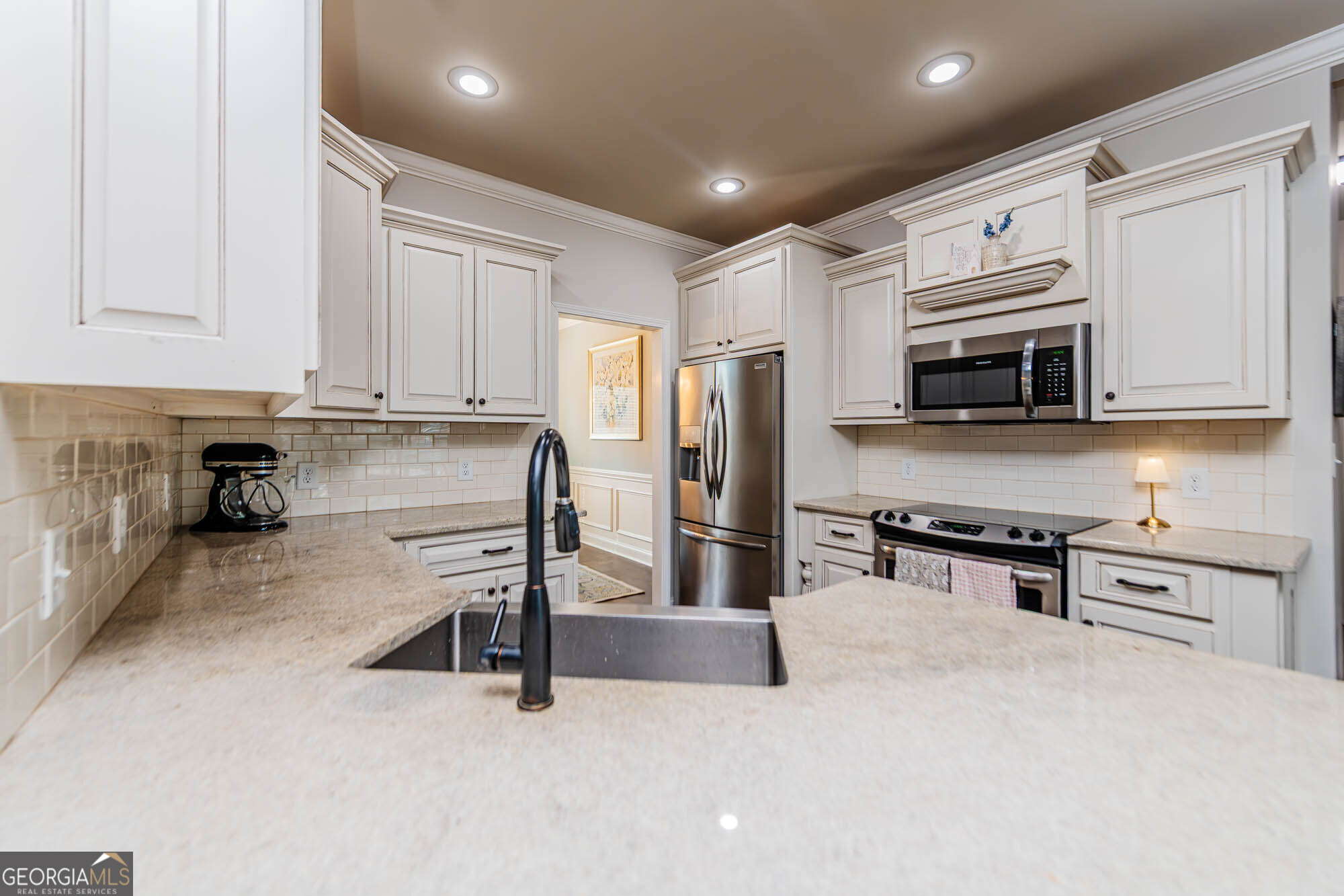 112 Bainbridge Lane Perry, GA 31069 - Photo 10 of 34 a kitchen with stainless steel appliances granite countertop a stove top oven a sink a refrigerator and white cabinets