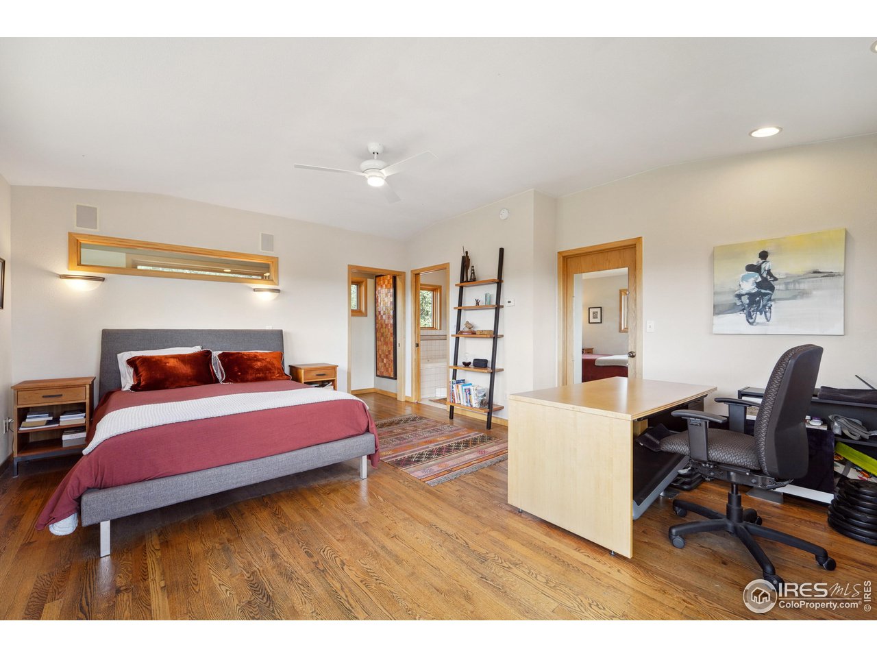 5055 Sugarloaf Road Boulder, CO 80302 - Photo 23 of 40 a bedroom with a bed a desk and chair with the wooden floor