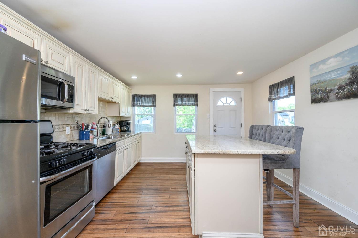 245 Washington Street Mount Holly, NJ 08060 - Photo 11 of 25 a kitchen with stainless steel appliances kitchen island granite countertop a stove a sink and a refrigerator