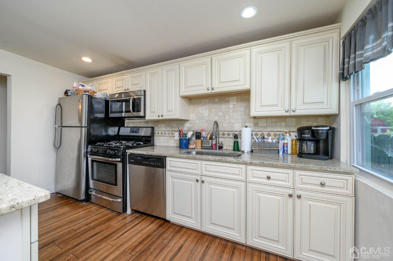 245 Washington Street Mount Holly, NJ 08060 - Photo 12 of 25 a kitchen with cabinets appliances and wooden floor