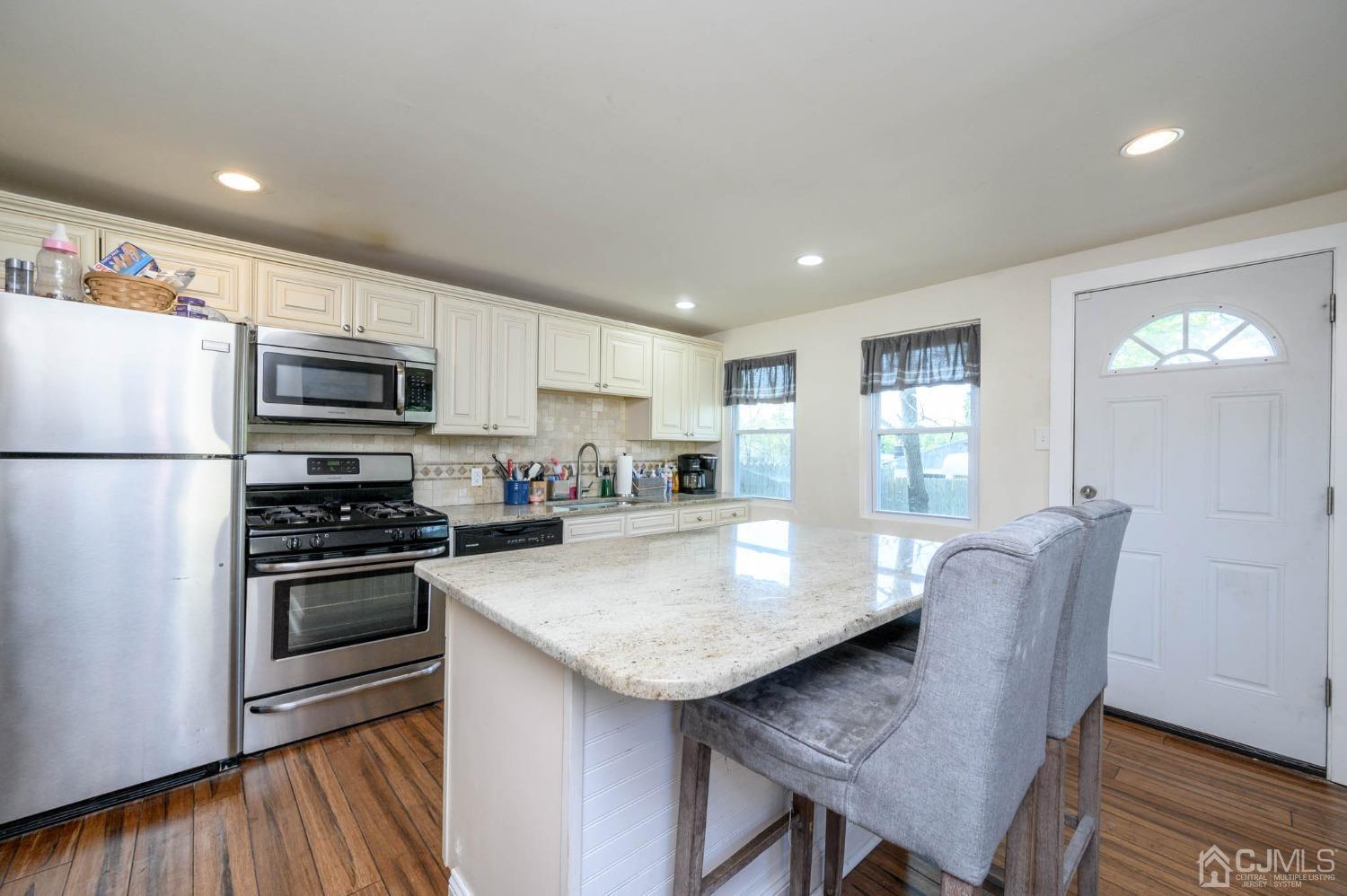 245 Washington Street Mount Holly, NJ 08060 - Photo 13 of 25 a kitchen with stainless steel appliances granite countertop a stove a refrigerator a sink a stove and a microwave