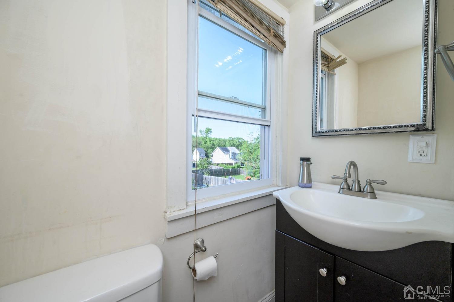 245 Washington Street Mount Holly, NJ 08060 - Photo 21 of 25 a bathroom with a sink a toilet and a mirror