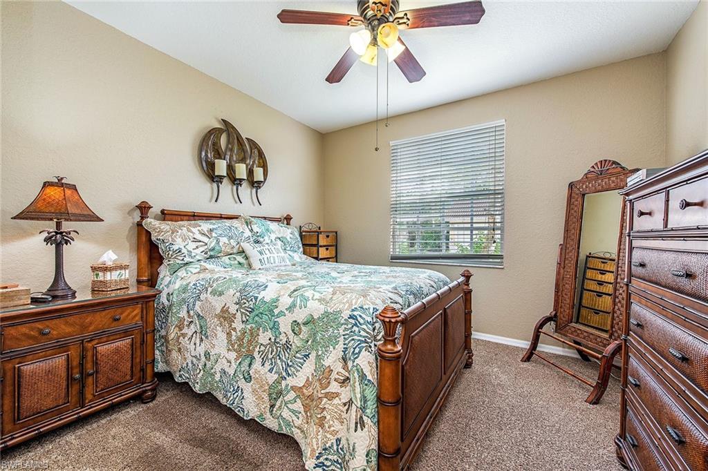 4680 St Croix Lane, Unit 514 Naples, FL 34109 - Photo 8 of 12 a bedroom with a bed and a chandelier