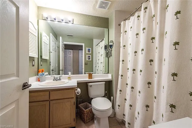 a bathroom with a double vanity sink toilet and a mirror