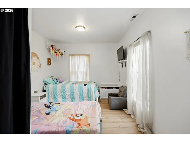 a bedroom with a bed window and dresser