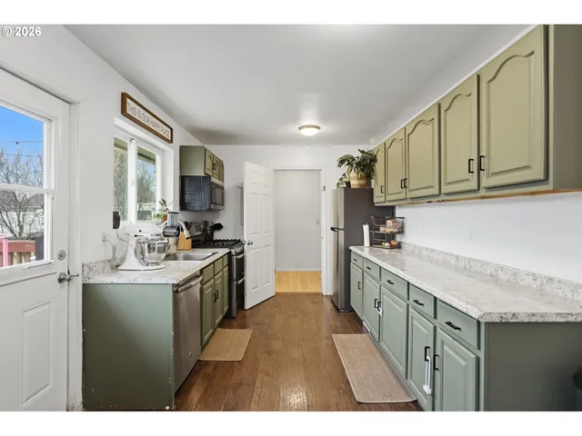 a kitchen with stainless steel appliances granite countertop a sink stove and cabinets