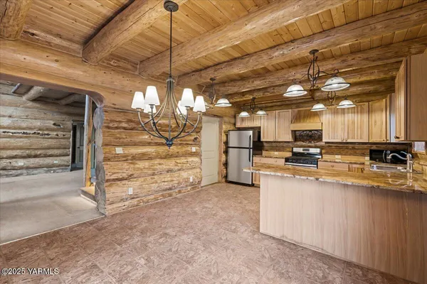 a view of a kitchen with refrigerator and a sink