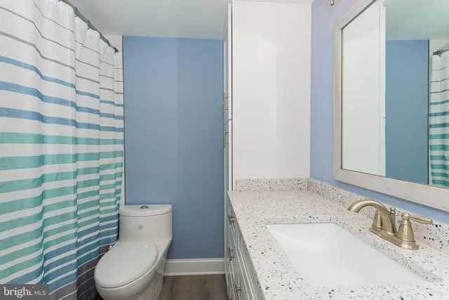 a bathroom with a granite countertop sink toilet and shower