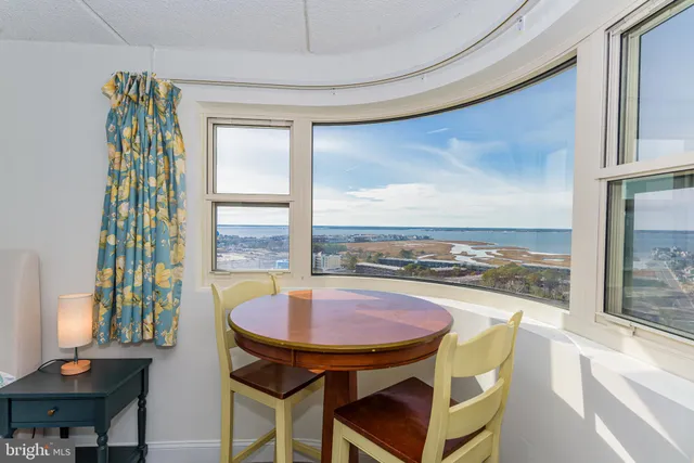 a living room with furniture and a dining table with kitchen view