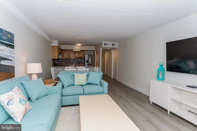 a kitchen with stainless steel appliances granite countertop a refrigerator a stove a sink a dining table and chairs