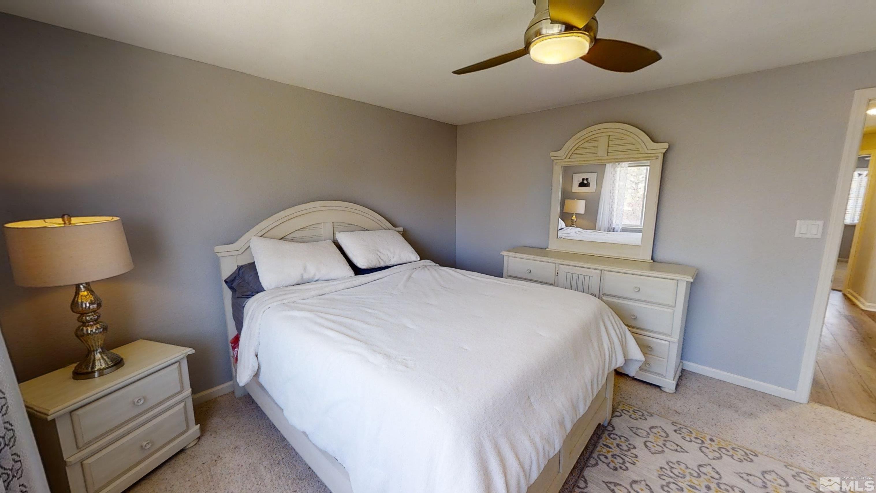 10018 Silver Star Drive Reno, NV 89521 - Photo 18 of 38 a bedroom with a bed and a chandelier