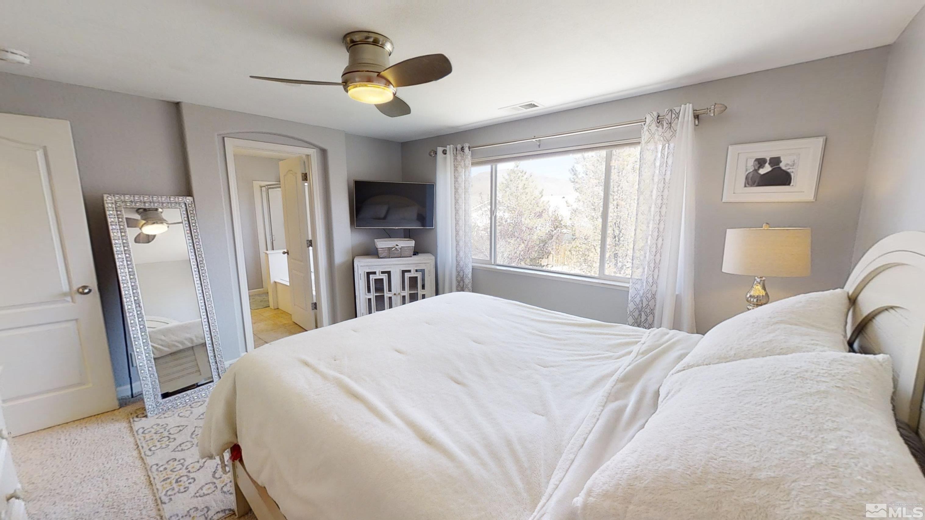 10018 Silver Star Drive Reno, NV 89521 - Photo 19 of 38 a bedroom with a bed and a chandelier