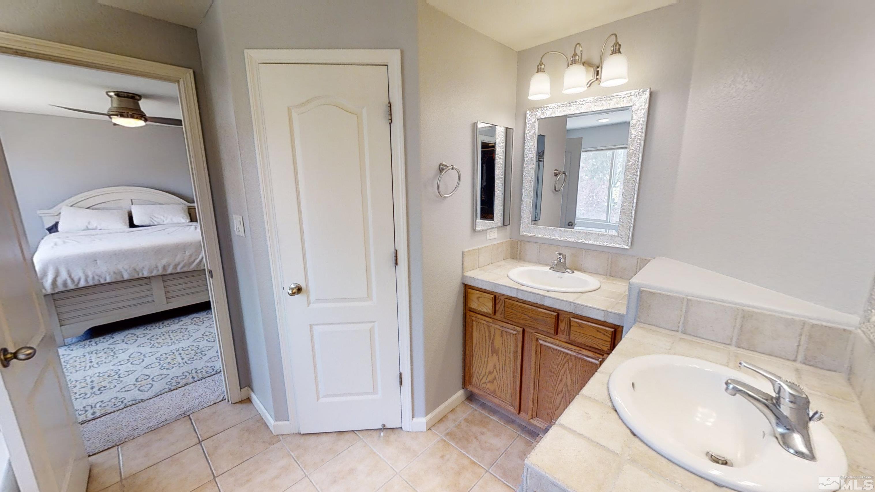 10018 Silver Star Drive Reno, NV 89521 - Photo 21 of 38 a en suite bathroom with a granite countertop sink and a mirror